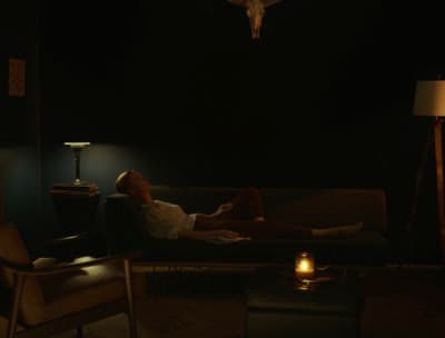 a woman laying on a couch in a dark room