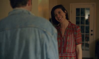 a smiling woman in a red dress standing next to a man