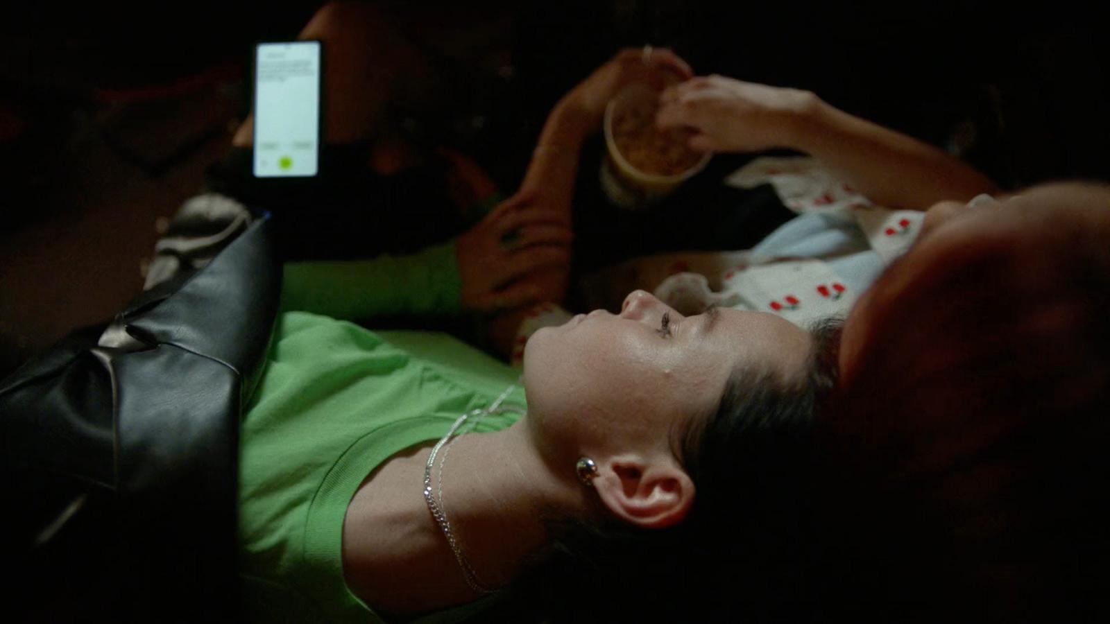 a woman laying down with a cell phone in her hand