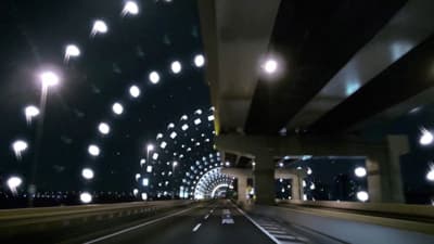 a car driving down a highway at night