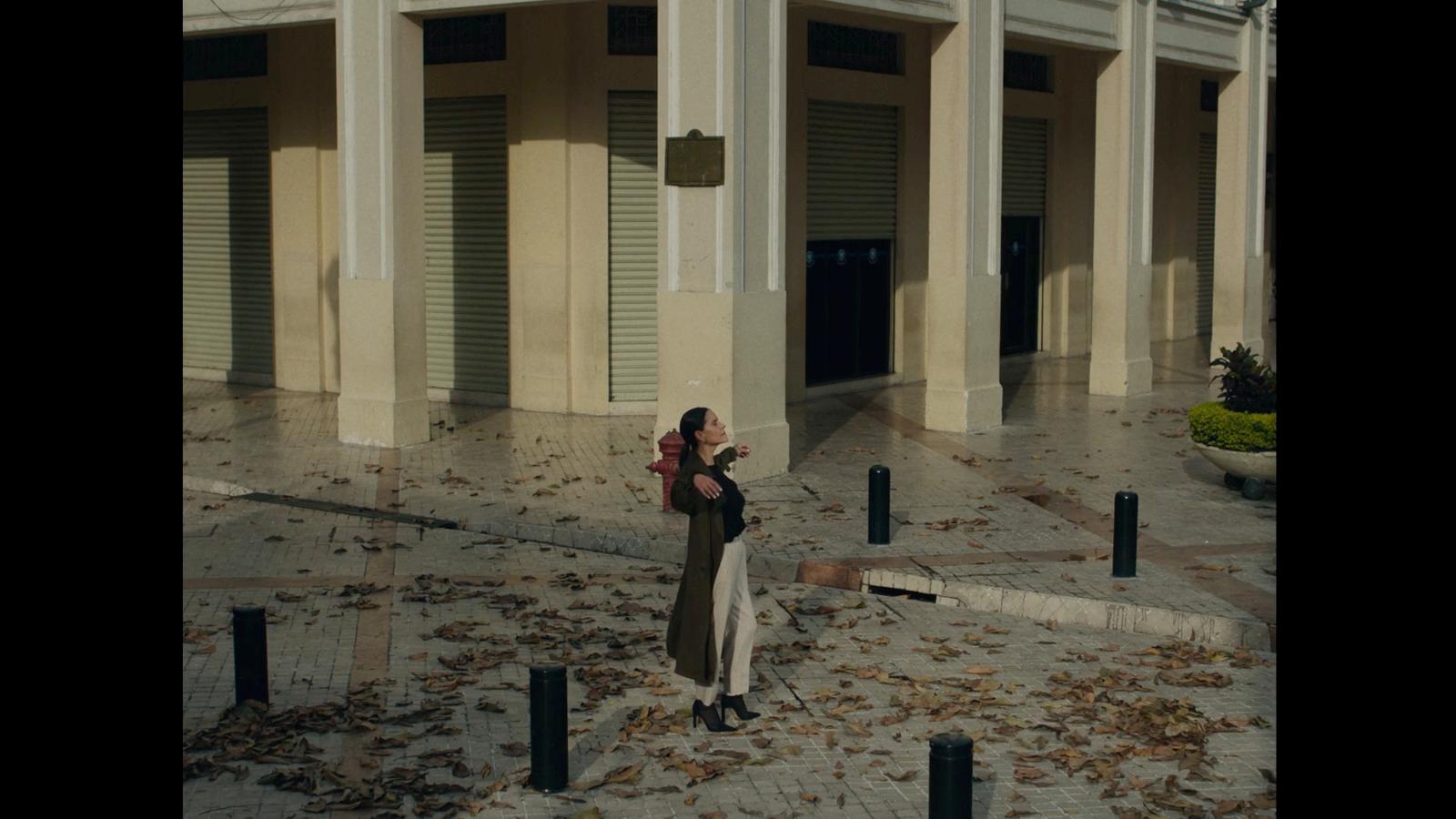 a woman standing in front of a building holding a cell phone