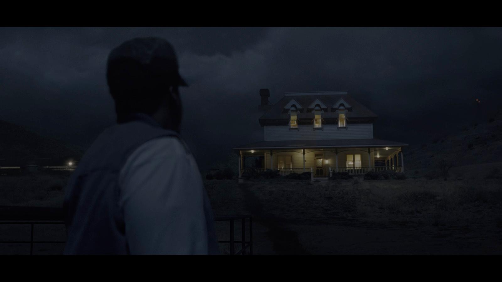 a man standing in front of a house at night