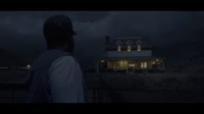 a man standing in front of a house at night