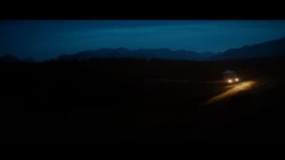 a car driving down a road at night