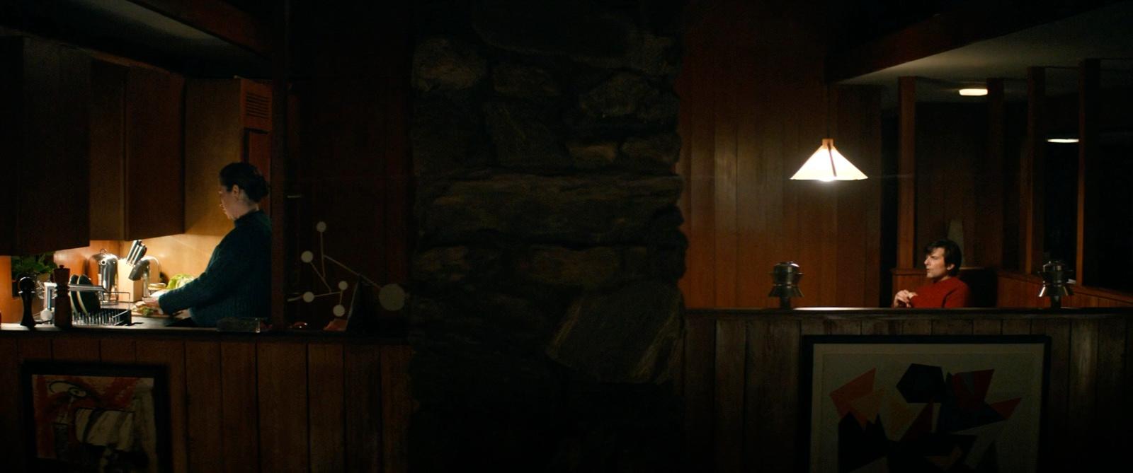 a woman sitting at a bar in a dimly lit room