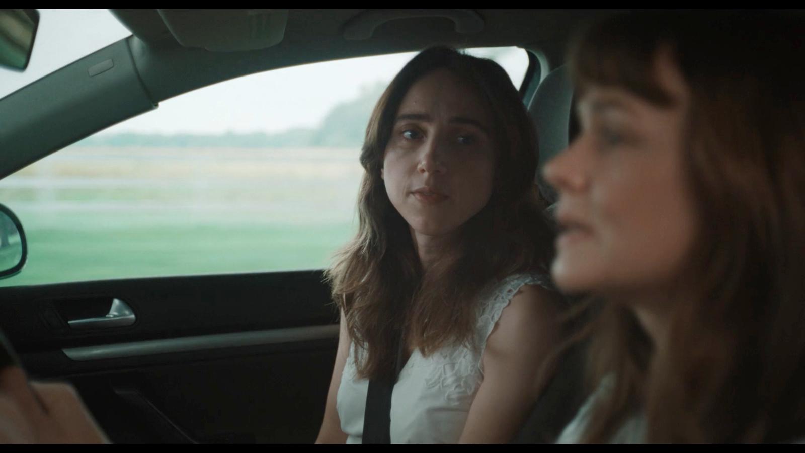 a woman sitting in a car with another woman behind her