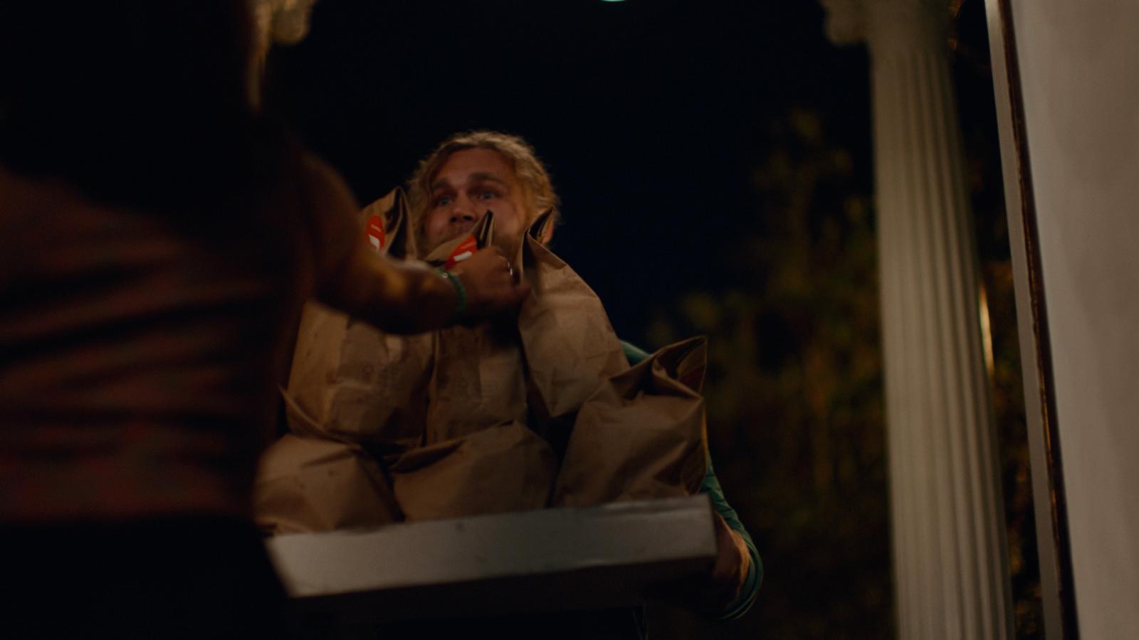 a man in a brown jacket brushing his teeth