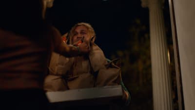 a man in a brown jacket brushing his teeth