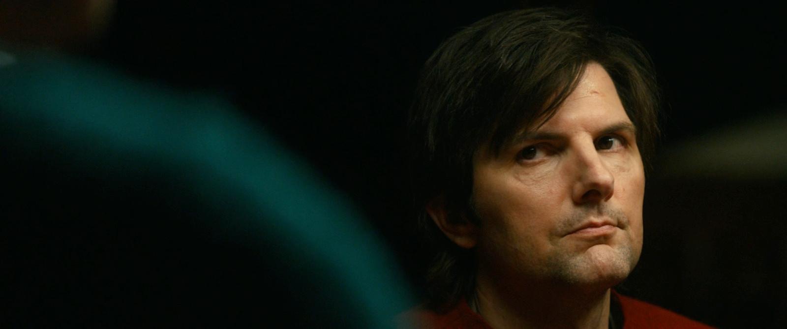 a man in a red shirt looking into the distance