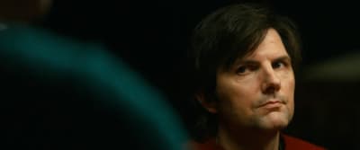 a man in a red shirt looking into the distance