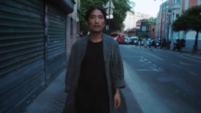 a man standing on the side of a street next to a building