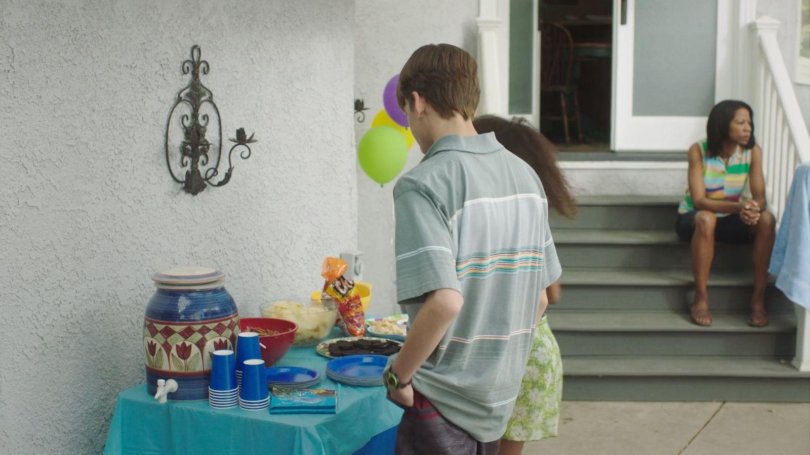 a boy and a girl standing outside of a house