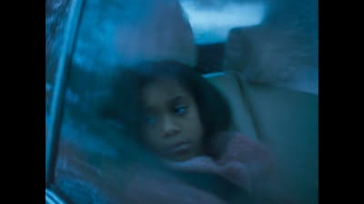 a young girl sitting in the back seat of a car