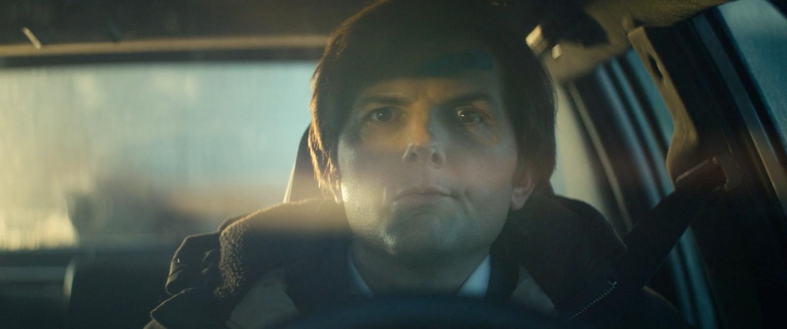 a man sitting in a car looking at the camera