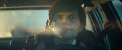 a man sitting in a car looking at the camera