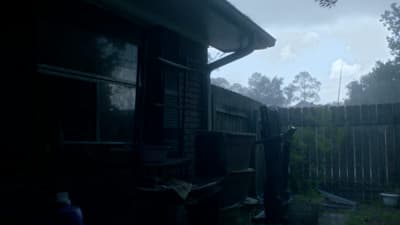 a dark picture of a back yard with a fence