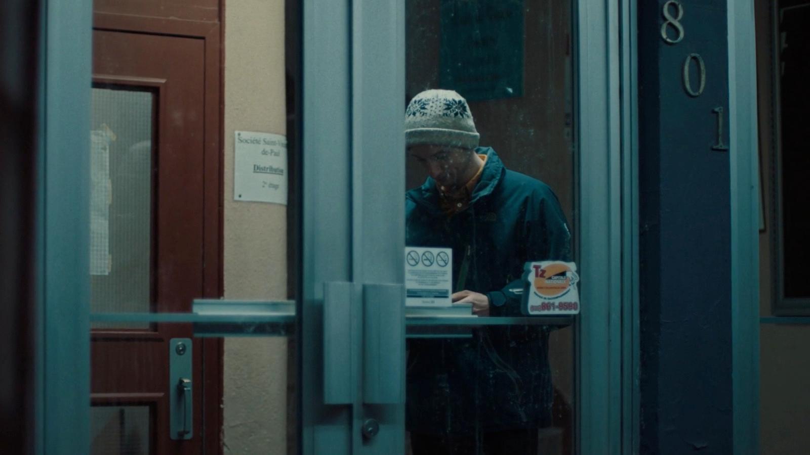 a man standing in front of a door with a cup of coffee
