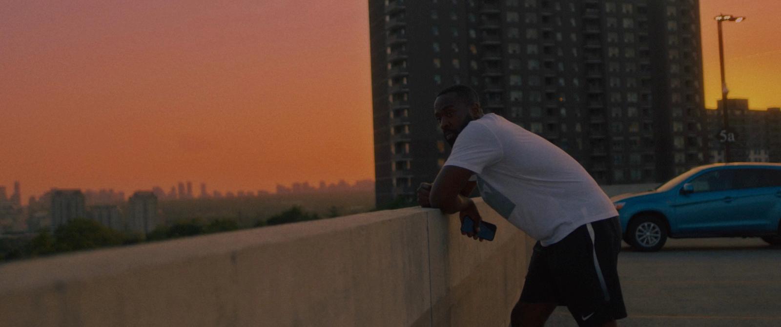 a man leaning against a wall with a skateboard