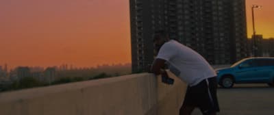a man leaning against a wall with a skateboard