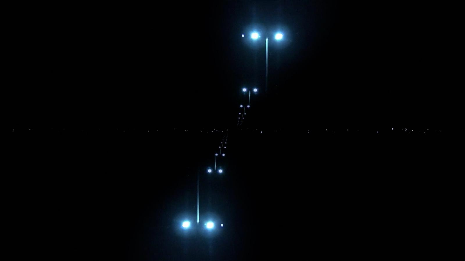 a couple of lights that are on a pole in the dark