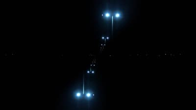 a couple of lights that are on a pole in the dark