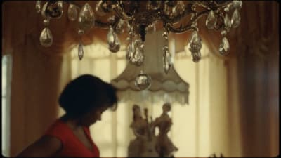 a woman standing in front of a chandelier