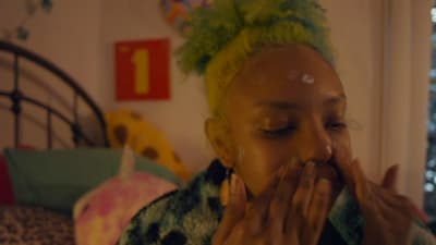 a woman with green hair covers her mouth
