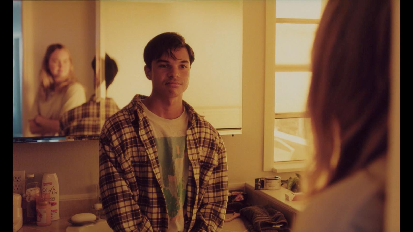 a man standing in front of a mirror in a bathroom