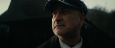 a man in a suit and tie wearing a hat