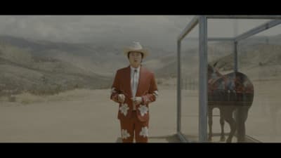 a man in a red suit and cowboy hat