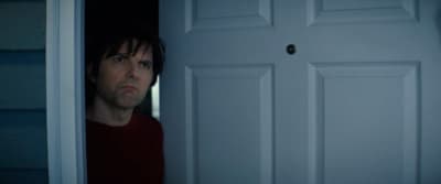 a man standing in front of a white door