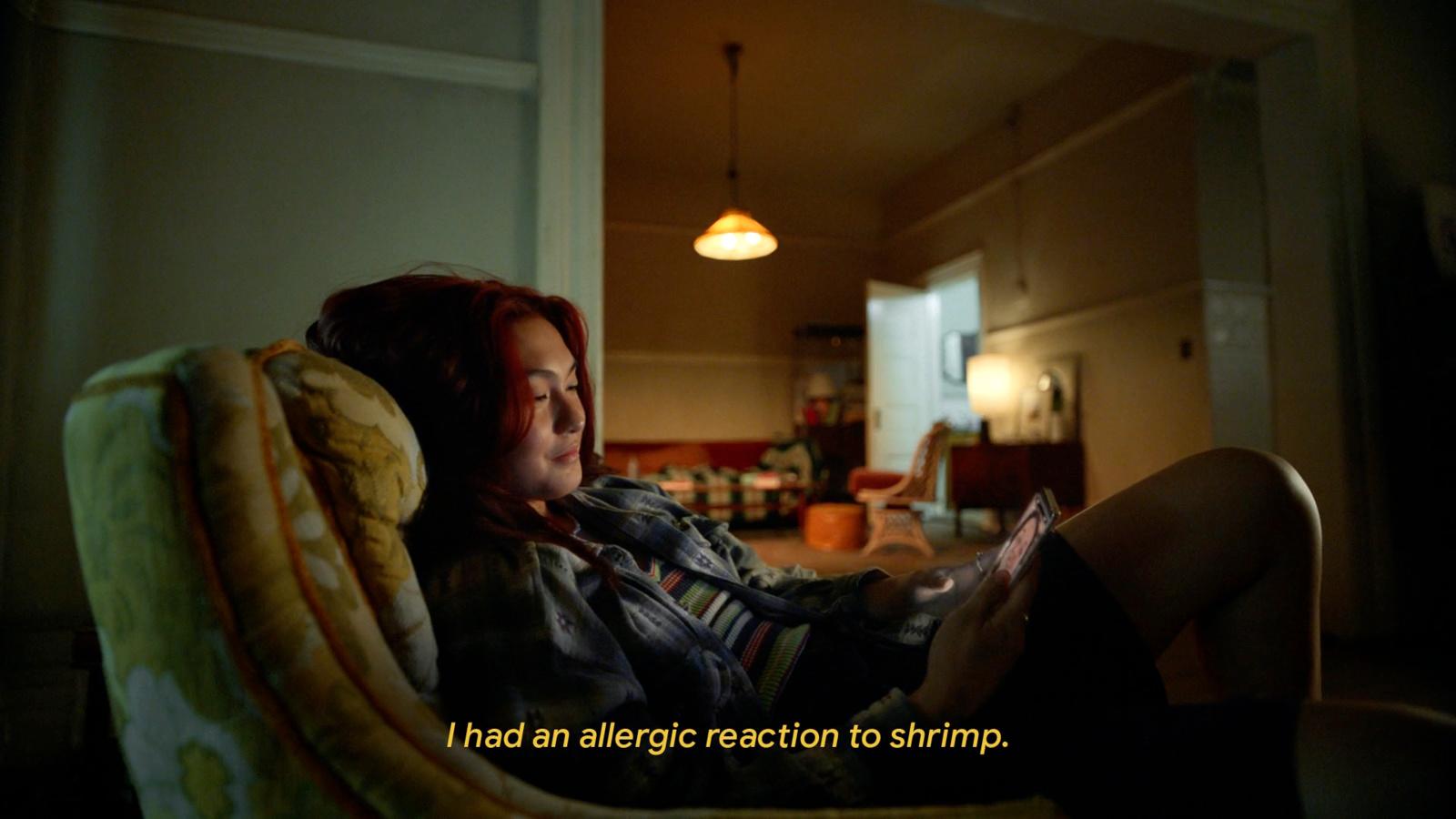 a woman sitting in a chair looking at a cell phone