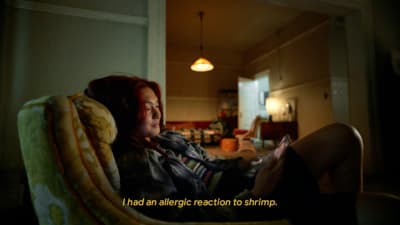 a woman sitting in a chair looking at a cell phone