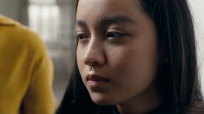 a close up of a person wearing a yellow shirt