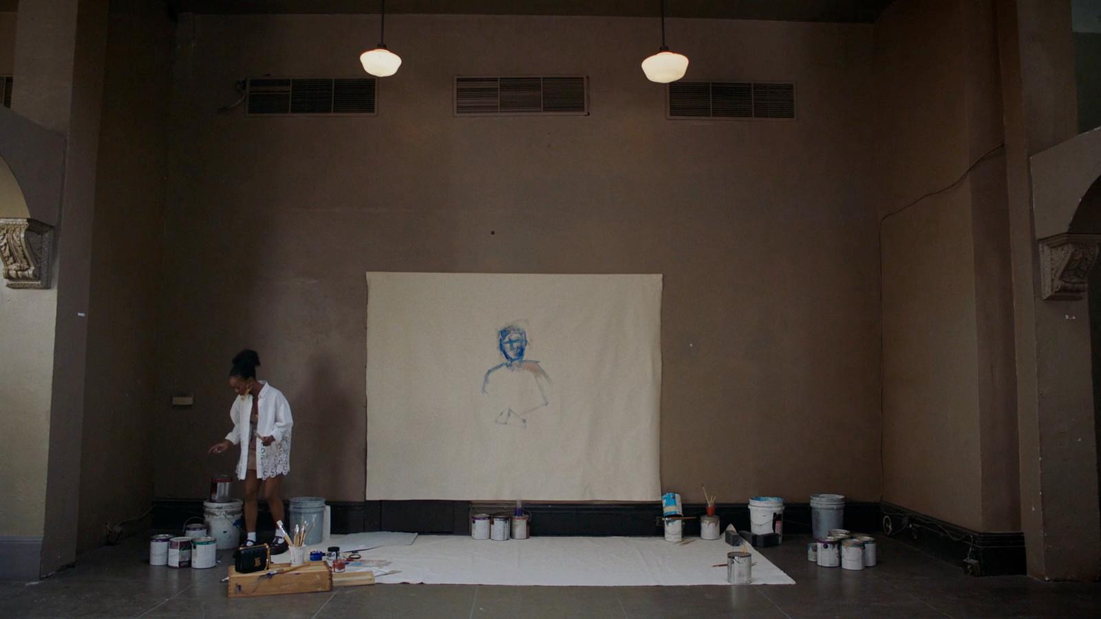 a man standing in front of a painting on a wall