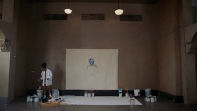a man standing in front of a painting on a wall