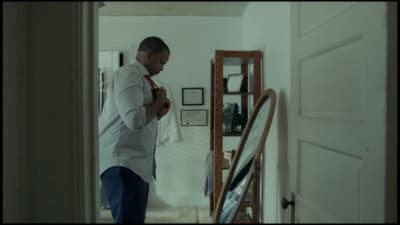 a man in a white shirt is standing in a hallway