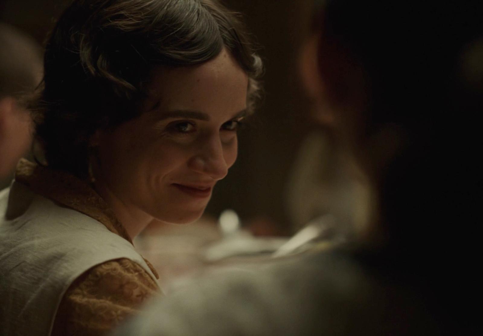 a woman in a white dress smiling at someone