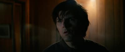 a man in a dark room with a light on