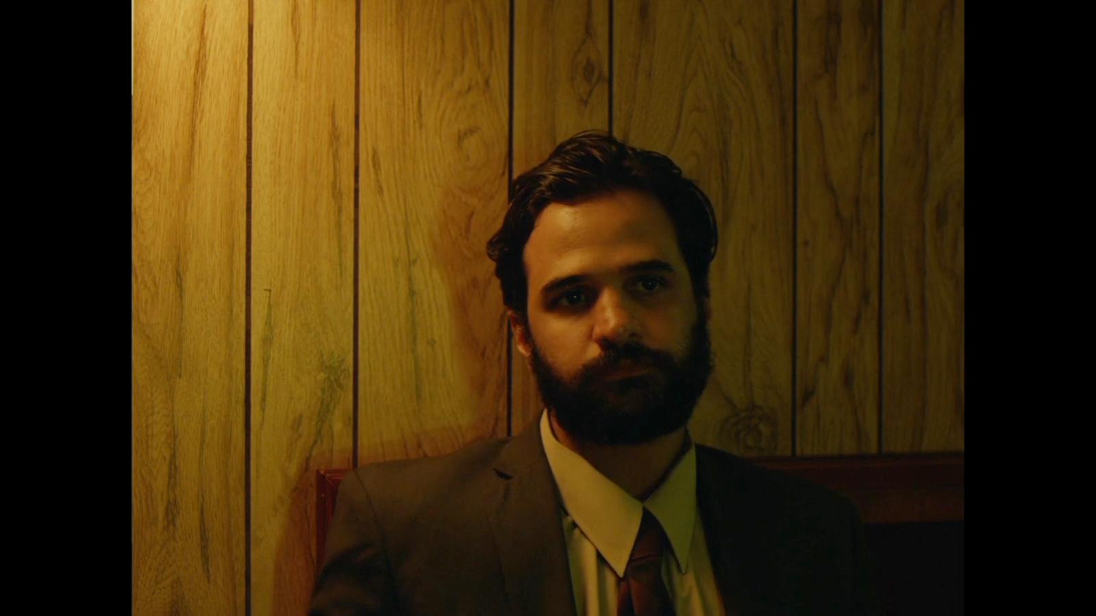a man with a beard wearing a suit and tie