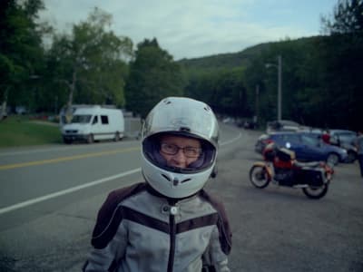 a man wearing a helmet standing next to a motorcycle