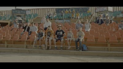 a group of people sitting on top of a bleachers