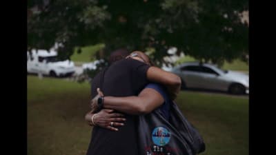 two people hugging each other in a park