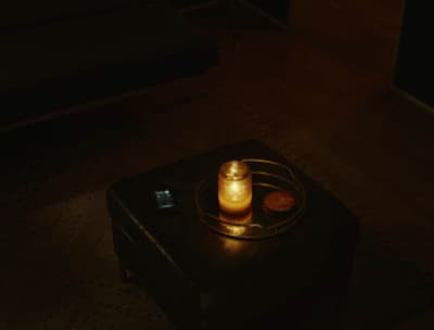 a lit candle sitting on top of a black suitcase