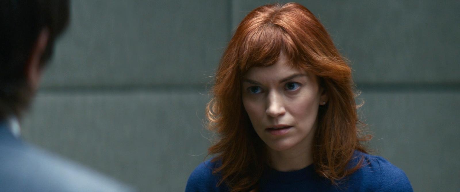 a woman with red hair is looking at a man
