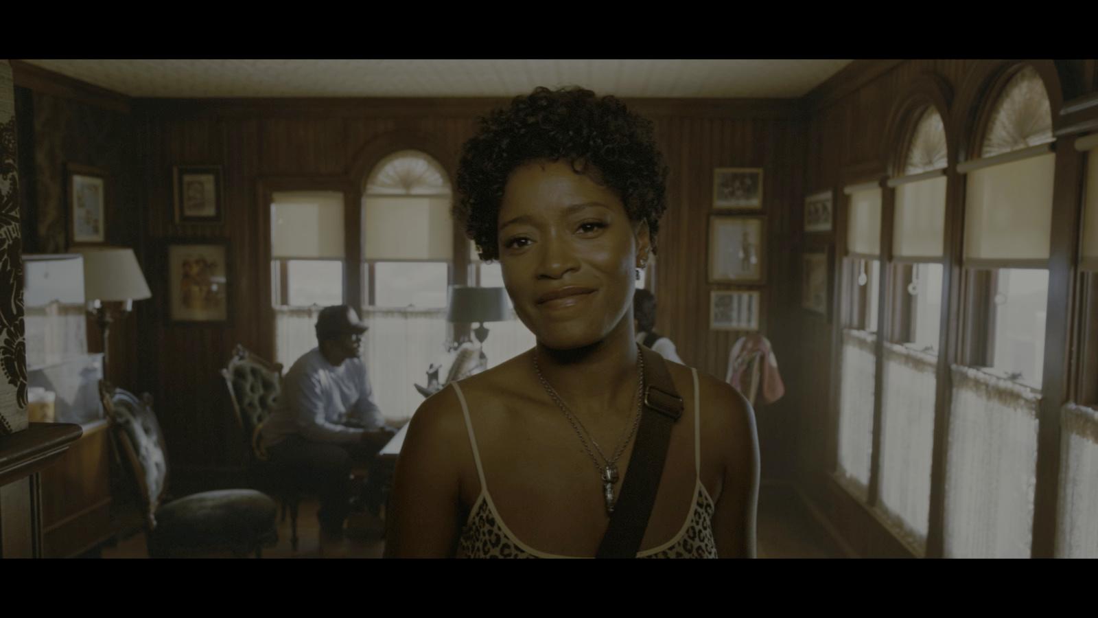 a woman standing in a living room next to a window