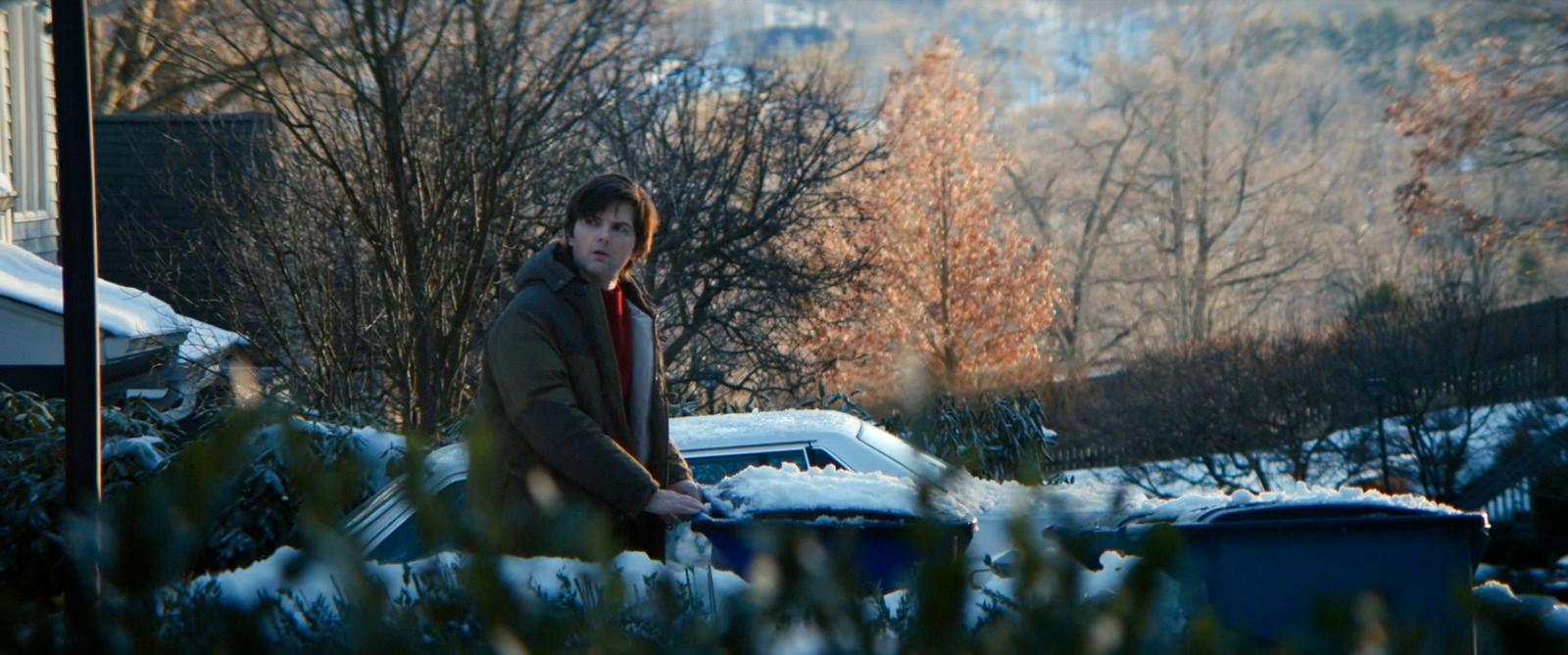 a man standing in front of a pile of snow