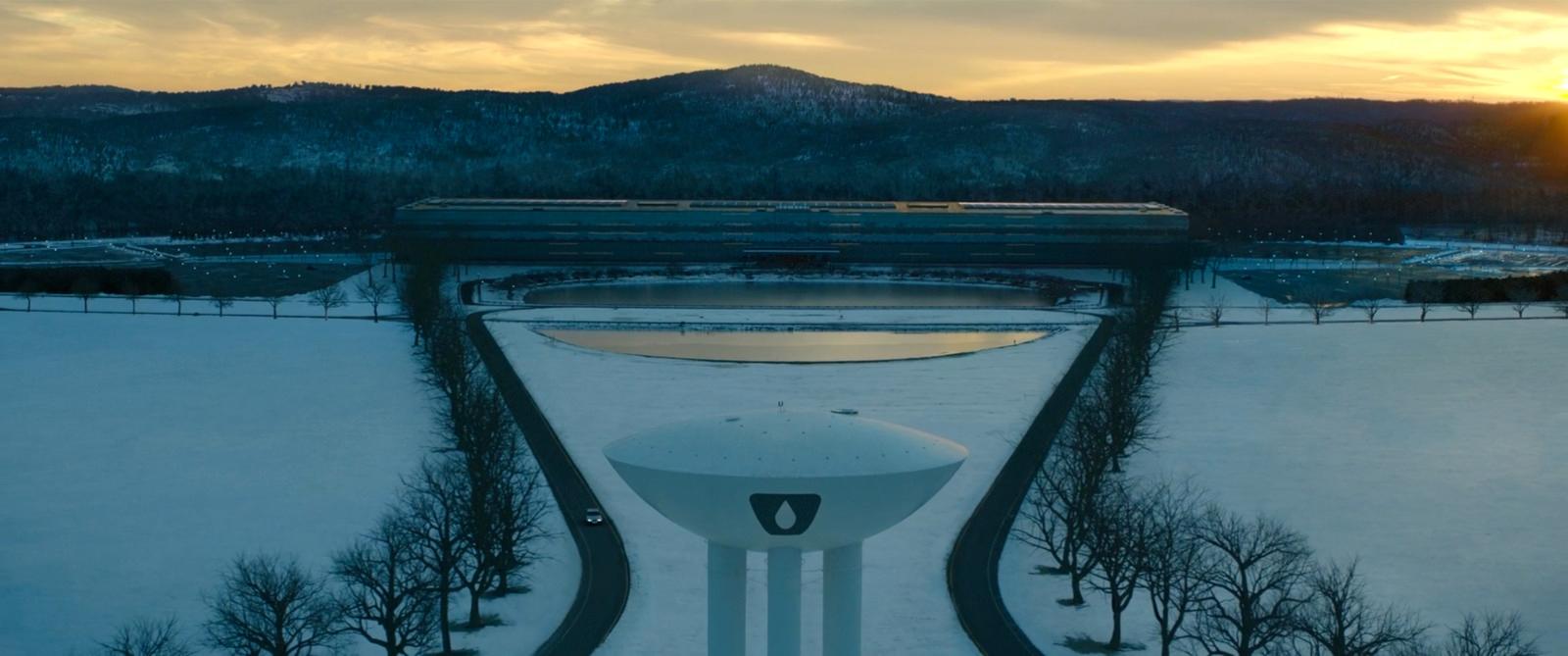 the sun is setting over a snow covered field