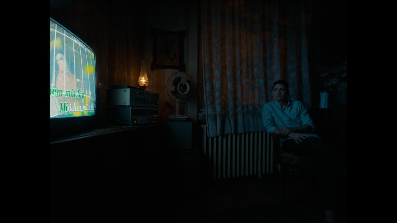 a man sitting in a chair in front of a flat screen tv