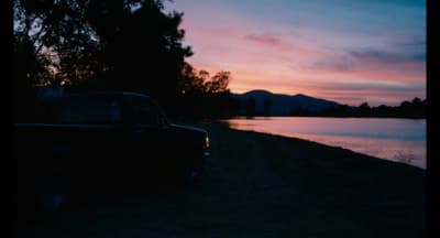 a truck parked next to a body of water